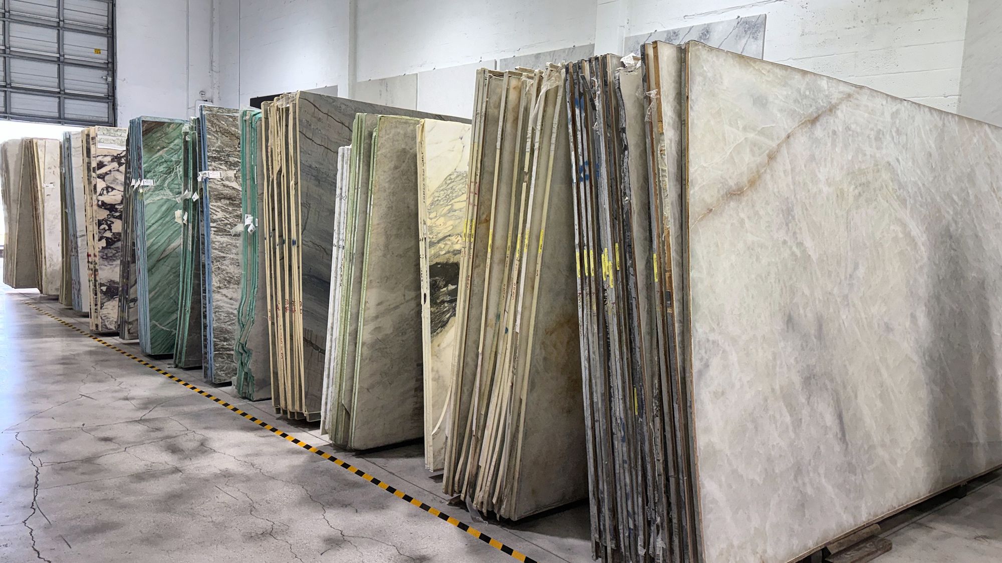 Aisle of quartzite and marble slabs in stock at All Stones FL, Doral